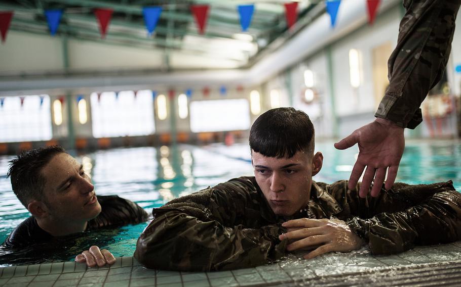 Michael Jagelski of 55th Military Police Company, 94th Military Police Battalion rests after finishing a water-survival event during a best-warrior competition at Camp Walker, South Korea, Monday, March 6, 2018.