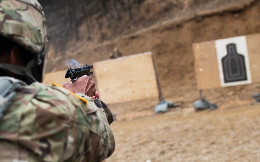 A 19th Expeditionary Sustainment Command best-warrior competitor fires his pistol during a stress shoot at Masan, South Korea, Wednesday, March 7, 2018.