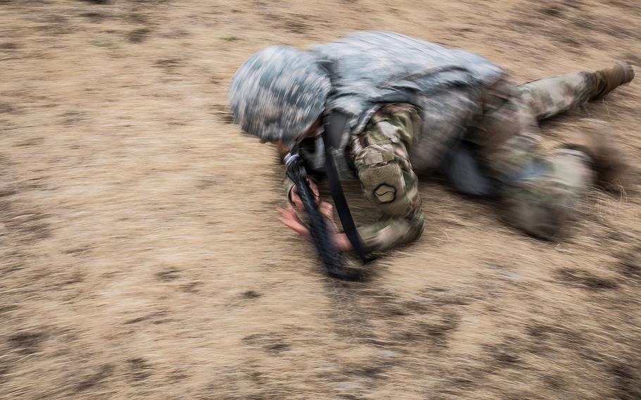 A 19th Expeditionary Sustainment Command best-warrior competitor low crawls during a stress shoot at Masan, South Korea, Wednesday, March 7, 2018.