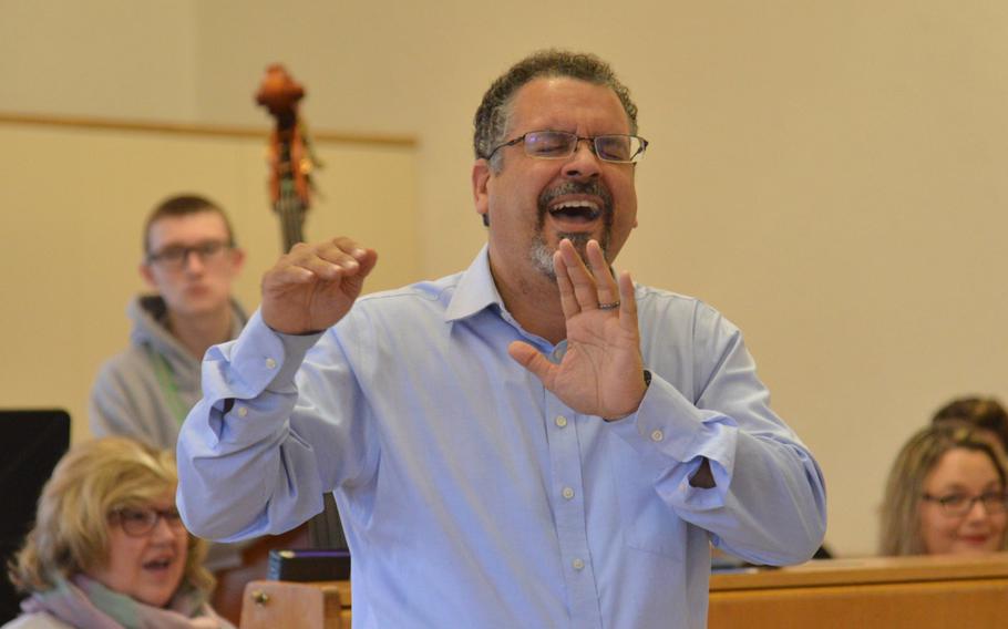Jose Rivera, this year's guest conductor for the choir at the annual DODEA-Europe Honors Music Festival, describes to the choir what he wants to hear during a rehearsal, Tuesday, March 13, 2018.