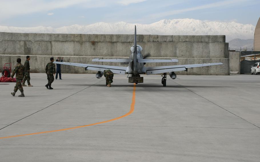 Afghan maintainers approach an A-29 Super Tucano light attack aircraft after it lands at Hamid Karzai International Airport in Kabul on Tuesday, March 6, 2018.