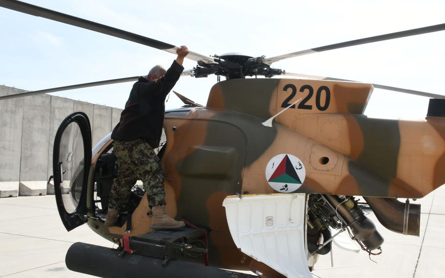 An Afghan maintainer inspects an MD-530 helicopter at Hamid Karzai International Airport on Tuesday, March 6, 2018.