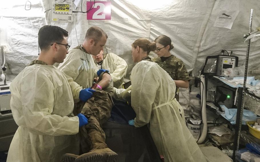 Soldiers from the 47th Combat Support Hospital in Baghdad check a patient for wounds on Nov. 24, 2017. They include, from left to right, Pfc. Michael Torres, Capt. Daniel Braun, Sgt. Jennifer Abbey, Dr. (Capt.) Cecily Vanderspurt and Spc. Brianna Camarena.
