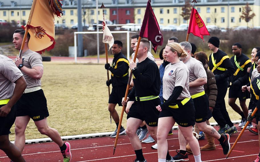 Soldiers with different units' flags running during the Bavarian Health Initiative 5K at Grafenwoehr, Germany, Friday, March 23, 2018.