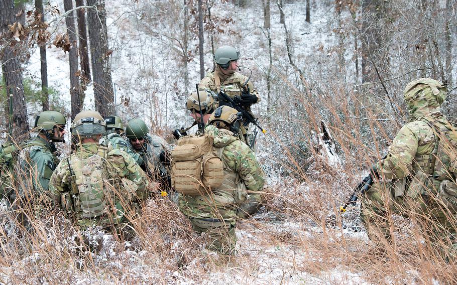 Soldiers with the 1st Security Force Assistance Brigade, wearing the darker Operational Camouflage Pattern uniforms, consult with role players representing Afghan soldiers, while they conduct a patrol to reach an objective Jan. 16 during training at the Joint Readiness Training Center at Fort Polk in Louisiana.