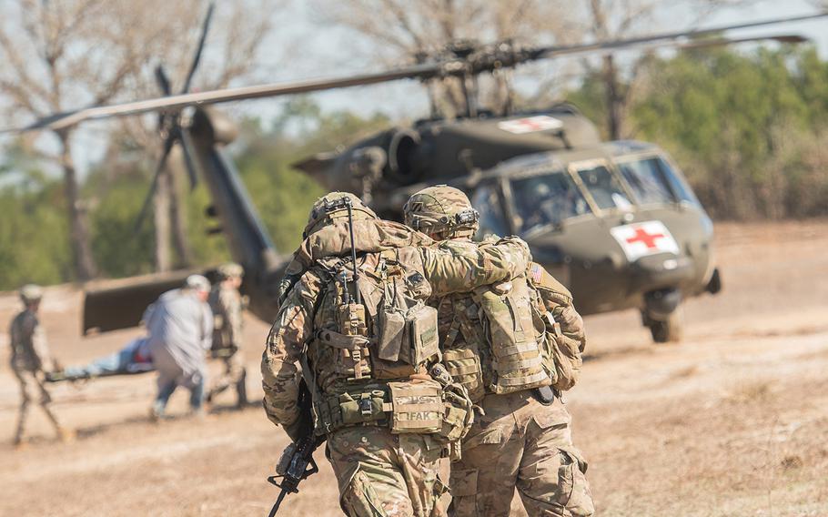 A soldier with the 1st Security Force Assistance Brigade helps another member of his unit move toward an HH-60 Black Hawk medical evacuation helicopter after he suffered a mock injury in a firefight scenario during training Jan. 15 at the Joint Readiness Training Center at Fort Polk, La. The 1st SFAB, the Army's first dedicated brigade of combat advisers, was preparing for a deployment this spring to Afghanistan.