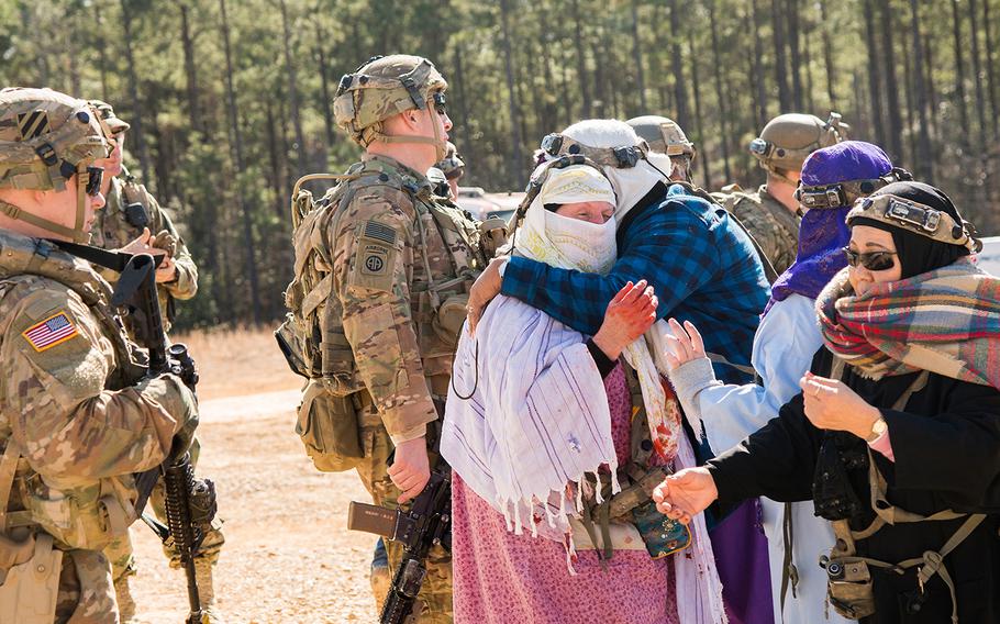 Role players portraying Afghan villagers embrace as soldiers with the Army's 1st Security Force Assistance Brigade look on following a training firefight during a mission rehearsal exercise Jan. 15 at the Joint Readiness Training Center at Fort Polk in Louisiana. The unit was preparing to deploy to Afghanistan where it will advise Afghan forces at the tactical level. 
