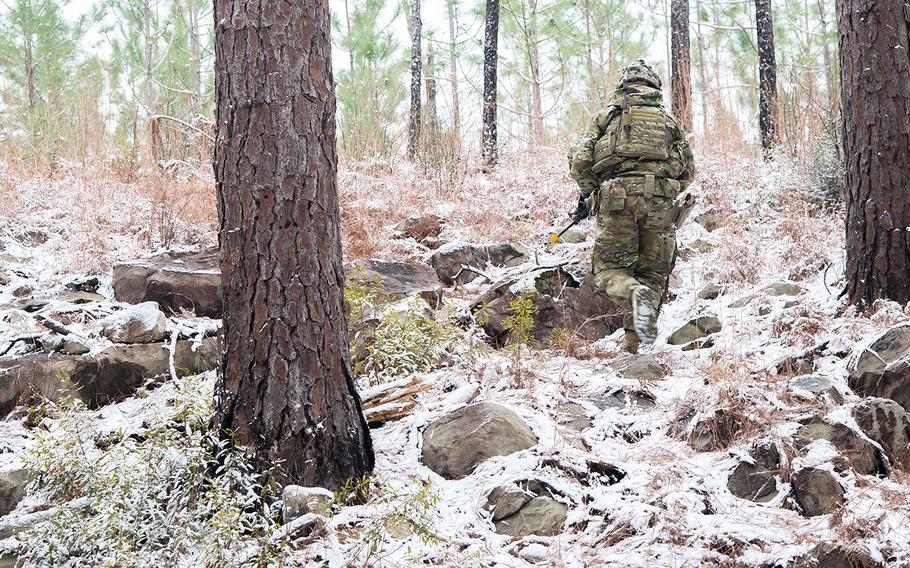 A soldier with the Army's 1st Security Force Assistance Brigade treks up a hill during a patrol on a rare frigid and snowy day at the Joint Readiness Training Center at Fort Polk, La. as part of a training rotation Jan. 16. 