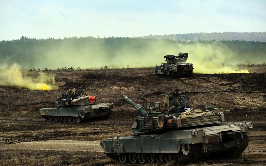 M1A2 Abrams tanks and Bradley Fighting Vehicles converge on a smoke signal during a live-fire exercise at Grafenwoehr, Germany, Wednesday, March 28, 2018. 