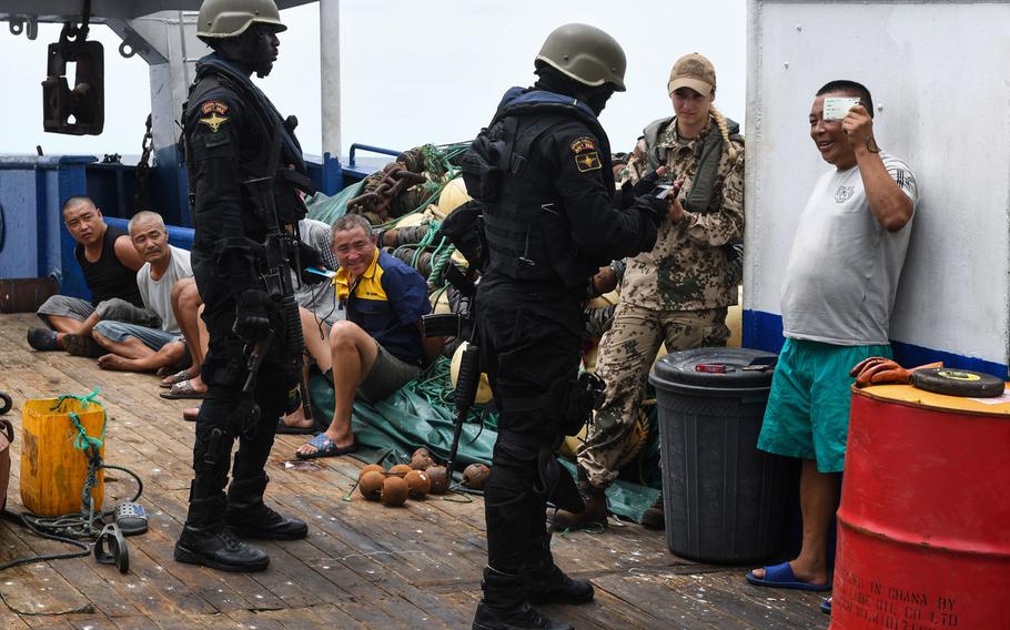 A German instructor observes a Ghanaian team collect evidence and documents from a crew on March 26, 2018, during a simulated raid. Thirty-one countries participated in the U.S.-led exercise aimed at strengthening cooperative policing in West African waters.