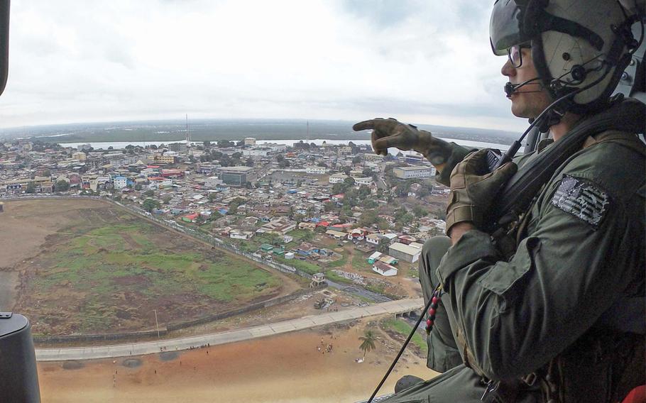 Petty Officer 2nd Class Tyler Skinner eyes terrain near Liberia from a Sea Hawk helicopter assigned to the "Ghost Riders" unit on March 24, 2018, during Obangame Express. The eight-day exercise is aimed at improving international maritime policing around the Gulf of Guinea.