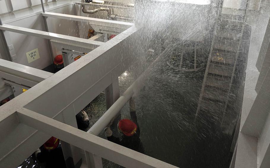 Sailors deal with a ruptured water pipe during recent damage-control training at Yokosuka Naval Base, Japan.