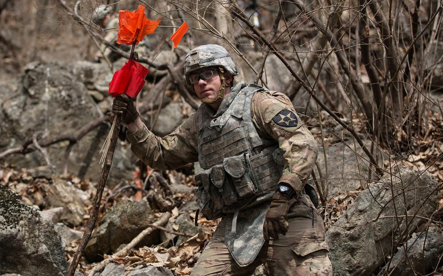 A soldier from the 11th Engineer Battalion carries clearance markers near a site thought to contain unexploded ordnance at Pocheon, South Korea, Thursday, March 29, 2018.