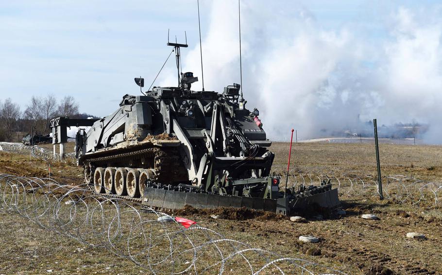An unmanned U.K. Terrier engineering vehicle clears mines during the Robotic Complex Breach Concept demonstration at Grafenwoehr, Germany, Friday, April 6, 2018.