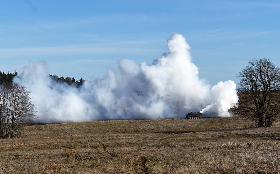 An unmanned M113 armored personnel carrier lays down smoke during the Robotic Complex Breach Concept demonstration at Grafenwoehr, Germany, Friday, April 6, 2018.