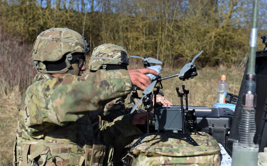 Spc. Brandon Burton, with the Army's 1st Infantry Division's 2nd Armored Brigade Combat Team, fits a chemical warfare detection device to an unmanned aerial system during the Robotic Complex Breach Concept demonstration at Grafenwoehr, Germany, Friday, April 6, 2018.