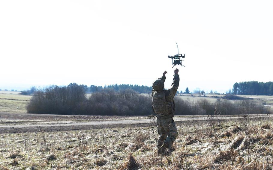 Spc. Brandon Burton, with the Army's 1st Infantry Division's 2nd Armored Brigade Combat Team, reaches for an Instant Eye unmanned aerial system during the Robotic Complex Breach Concept demonstration at Grafenwoehr, Germany, Friday, April 6, 2018.