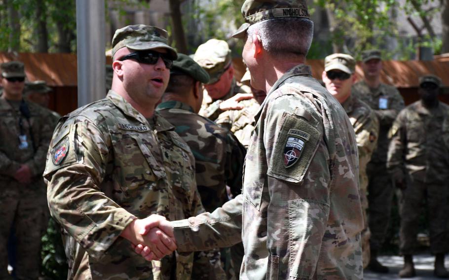 Navy Cmdr. William Danchanko, left, is greeted by Gen. John Nicholson, the top U.S. commander in Afghanistan, during an operation Proper Exit ceremony at NATO's Resolute Headquarters in Kabul on Saturday, April 7, 2018. 


