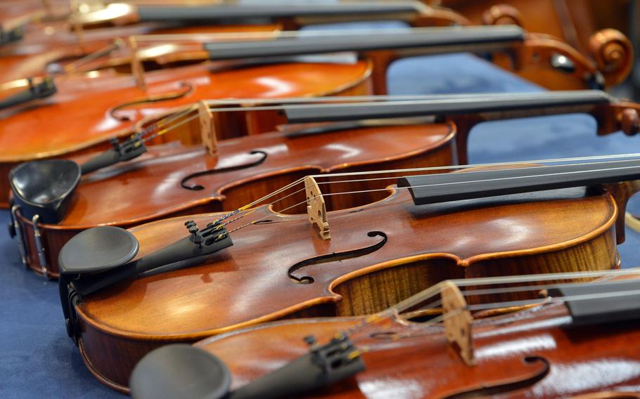 A row of violins on display at the Musikmesse in Frankfurt, Germany, Wednesday April 11, 2018. The music trade fair runs through Saturday at the city's fair grounds.