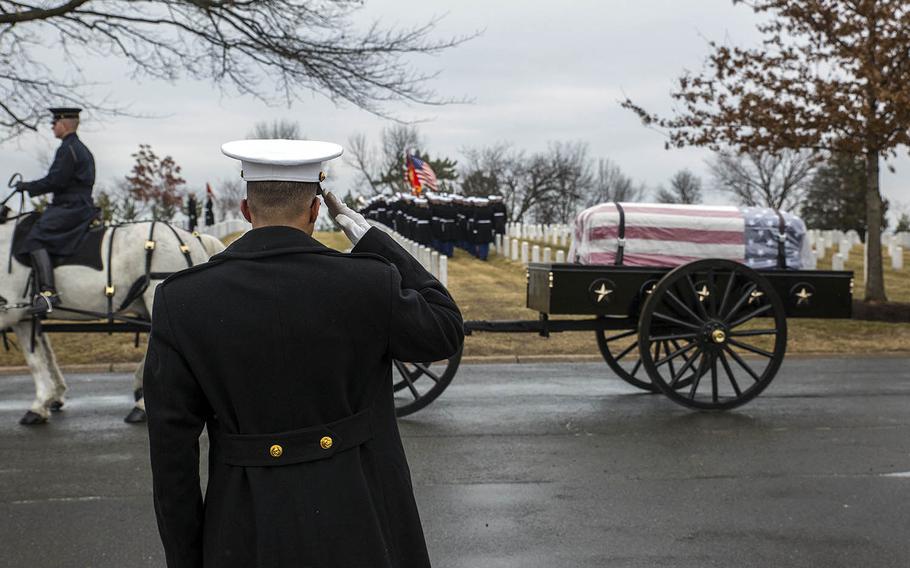 A Marine salutes a passing horse-drawn caisson during a full-honors funeral in February at Arlington National Cemetery.