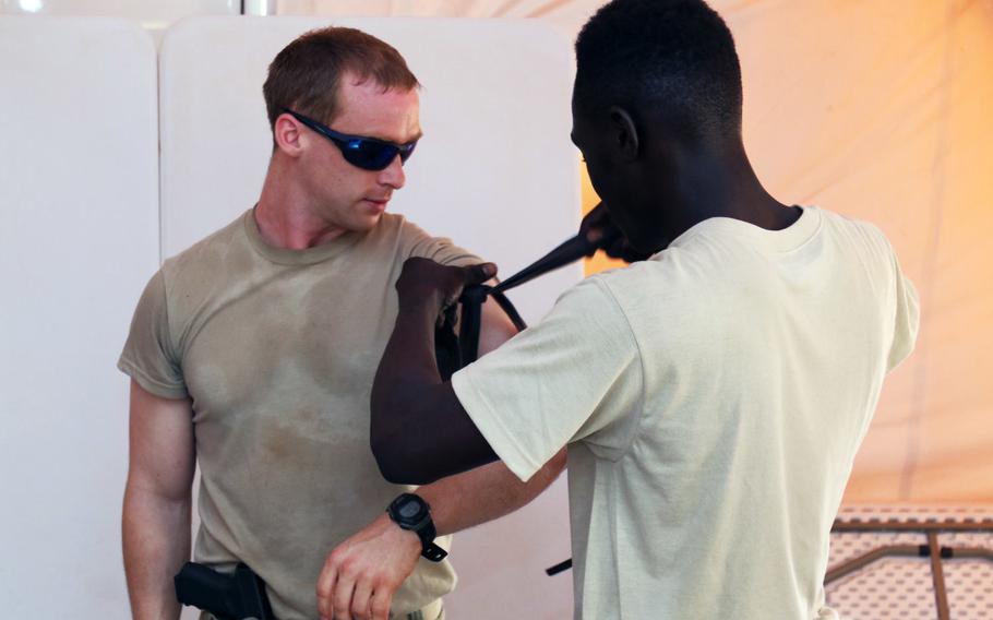 A Senegalese soldier applies a tourniquet to Staff Sgt. Spencer, a U.S. Army Special Forces Operational Detachment Alpha medical sergeant in 3rd Special Forces Group, during Exercise Flintlock 2018 in Tahoua, Niger, April 11, 2018.