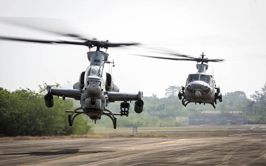 A Marine Corps AH-1Z Viper, foreground, and a UH-1Y Venom lift off at U-Tapao International Airport, Thailand, Feb. 10, 2018.