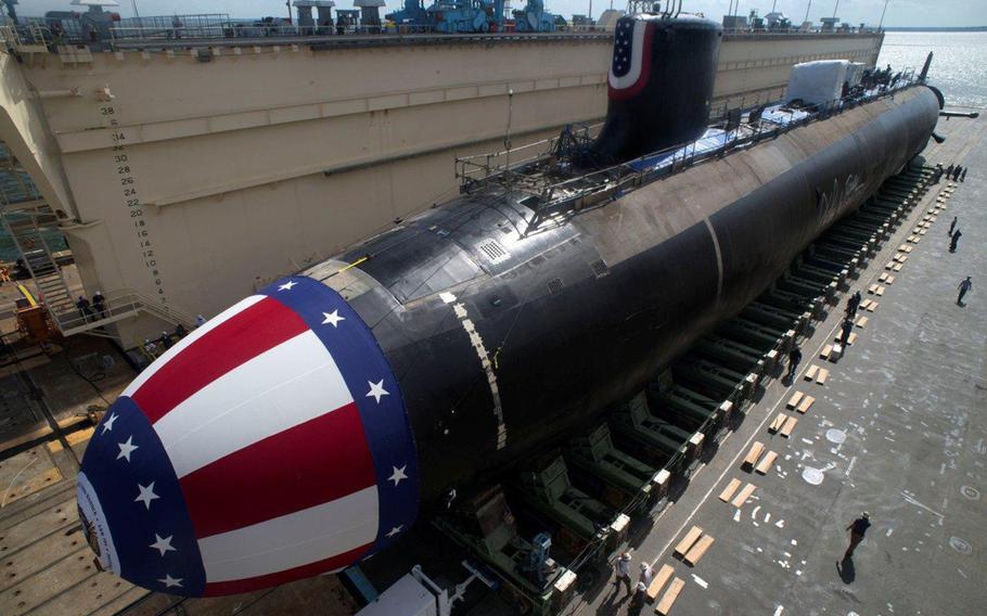 The Virginia-class attack submarine USS John Warner is moved to dry dock in Newport News, Va., in preparation for its 2014 christening.