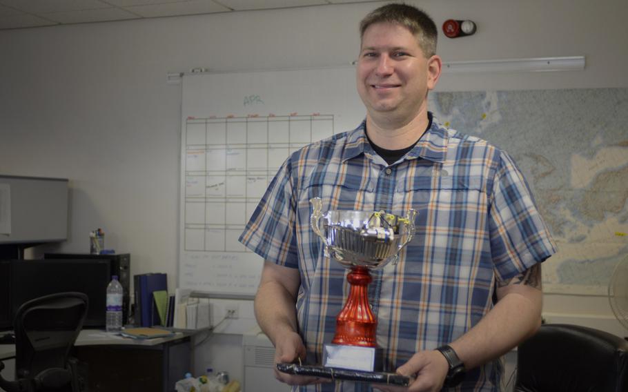 Michael Norwood, a civilian with the 100th Operations Support Squadron, holds an Innovation of the Quarter award his team earned for developing a custom USB adapter to replace outdated PCMCIA Cards used to transfer flight plans and mission onto KC-135 Stratotankers, at RAF Mildenhall, England, Wednesday, April 25, 2018.