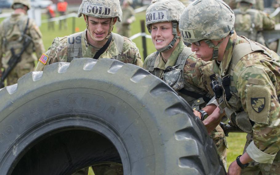 U.S. Military Academy Cadet Taylor England, center right, helps her teammates flip over a tractor tire during the Sandhurst Military Skills Competition at West Point, N.Y., April 14, 2018. England, the top-ranked cadet who is branching infantry, plans to serve with the 173rd Airborne Brigade when she completes the Infantry Basic Officer Leader Course.