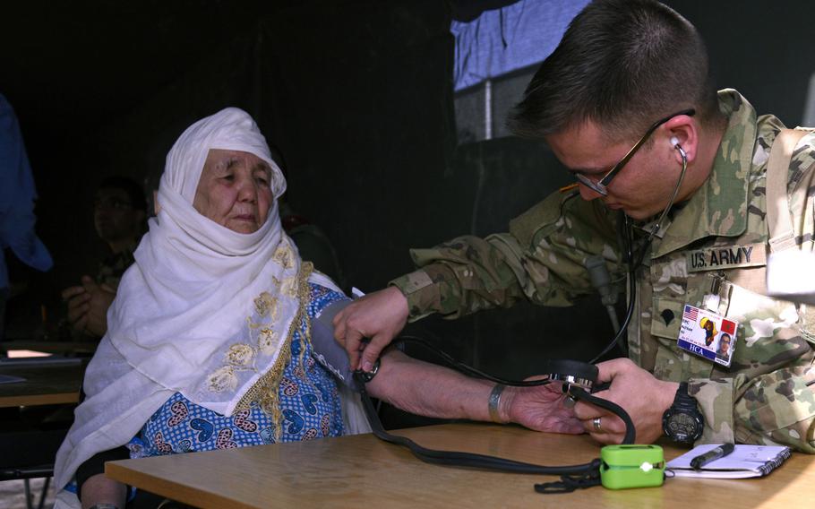 Specialist Nathan Ro, a combat medic with the Utah National Guard Medical Detachment, checks a patient's blood pressure during the humanitarian civic assistance component of Exercise African Lion 2018 in Bounaamane, Morocco, April 19, 2018.
