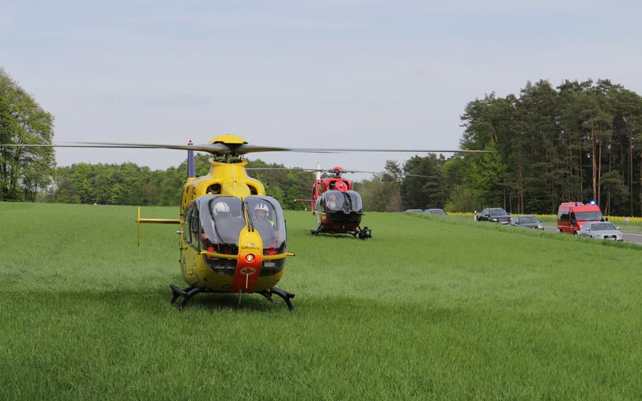 Two helicopters wait to transport the injured after two U.S. Army soldiers and two Germans were seriously injured in a car crash near Grafenwoehr, Germany, Saturday, April 28, 2018.