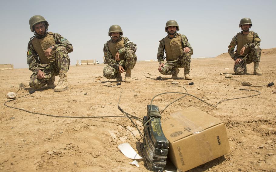 Soldiers with the Afghan National Army 215th Corps wait for the command to detonate their blasting caps during a live-fire examination at Camp Shorabak, Afghanistan, April 17, 2018. 