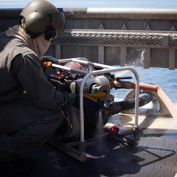 Petty Officer 2nd Class Daniel Bernado, a Landing Craft Air Cushion loadmaster, operates a water pump used to fight fires aboard landing craft air cushions, or LCACs, while training near Sasebo Naval Base, Japan, April 19, 2018.