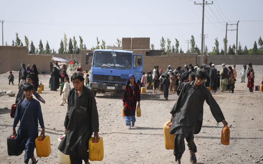 Afghan children draw water delivered by the city of Herat to the estimated 20,000 internally displaced people who have settled into camps on the outskirts of Herat due to drought and warfare.