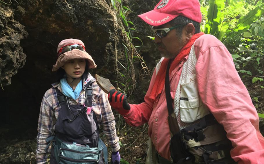 Kuentai-USA secretary general Yukari Akatsuka, left, and founder Usan Kurata, study pottery fragments found in former Japanese fighting positions during the Battle of Okinawa in the Okinawan jungle May 9, 2018, while looking for the remains of a missing U.S. Marine.