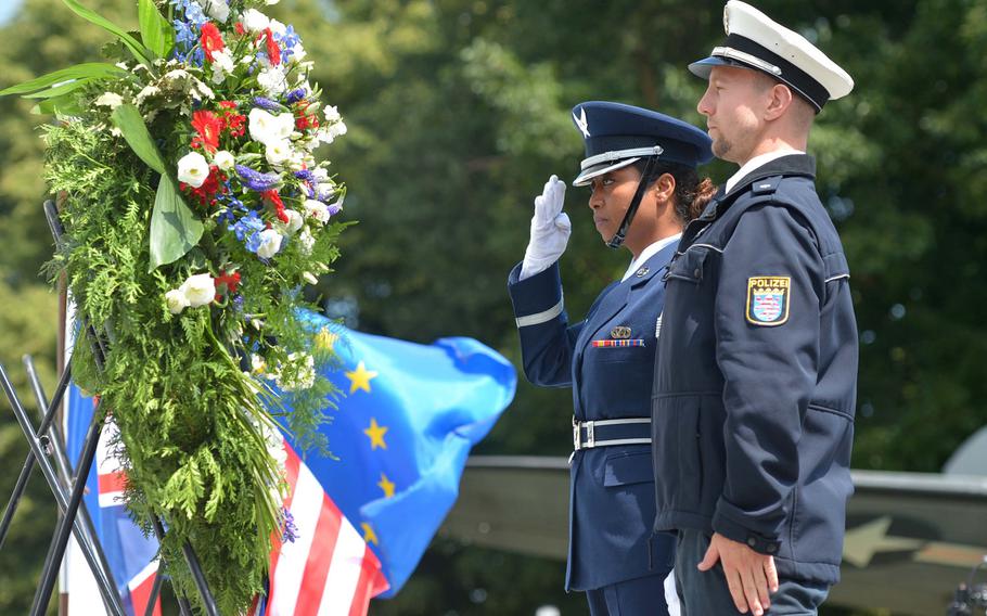 Airman 1st Class Marie Pough salutes after she and a German police officer place a wreath on the Berlin Airlift Memorial at Frankfurt airport during a ceremony marking the 70th anniversary of the start of the Berlin Airlift, Tuesday, June 26, 2018.