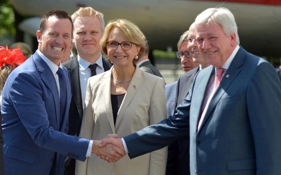 Richard Grenell, the U.S. ambassador to German, left, shakes hands with Hesse Minister President Volker Bouffier after arriving at the Berlin Airlift Memorial at Frankfurt airport for the ceremony marking the 70th anniversary of the Berlin Airlift, Tuesday, June 26, 2018. At center is Anne-Marie Descotes, France's ambassador to Germany, behind her at left is Robbie Bulloch, the deputy head of mission at the British Embassy in Berlin.
