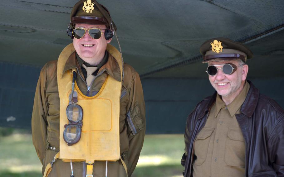 Two re-enactors dressed as airlift-era pilots hide from the sun under the wing of the C-47 at the Berlin Airlift Memorial at Frankfurt airport. The 70th anniversary of the start of the airlift was marked with a ceremony at the memorial on Tuesday, June 26, 2018.