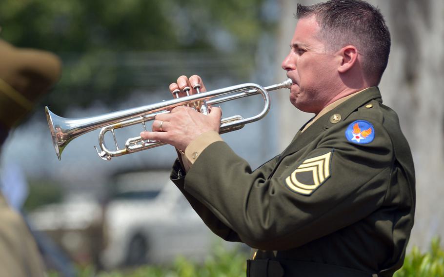 Master Sgt. Eugene King of the USAFE Band plays taps during a ceremony marking the 70th anniversary of the start of the Berlin Airlift at Frankfurt airport, Tuesday, June 26, 2018.