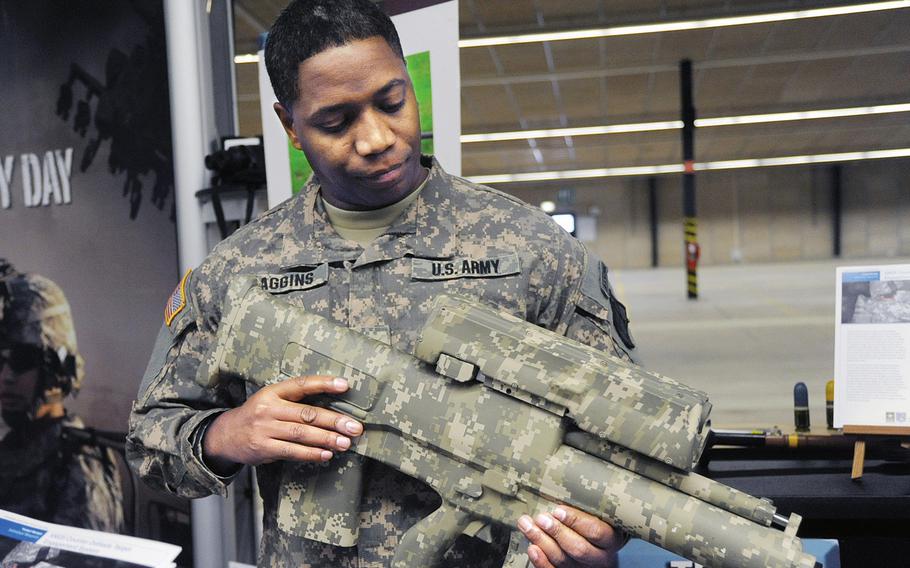 Maj. Elliot Caggins talks about the XM25 Counter Defilade Target Engagement System at a military expo in Kaiserslautern, Germany, in 2009.