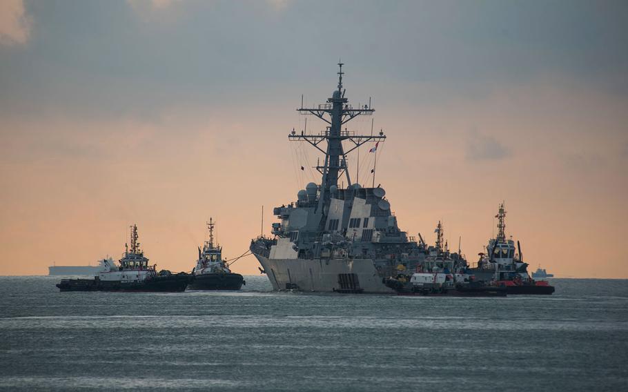 The USS John S. McCain is towed away from the pier at Changi Naval Base, Singapore, to meet the heavy lift transport vessel MV Treasure, Oct. 5, 2017.