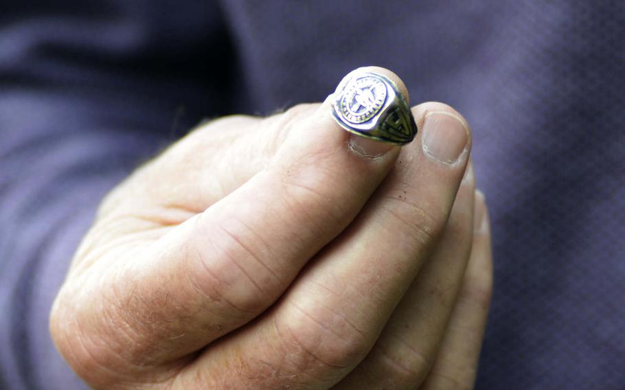 Ken Spatz holds his father's 1941 high school graduation ring near the crash site where he died during World War II in Ridgewell, England, Friday, Aug. 31, 2018. About a decade ago, British farmer Andy Cox found the ring near a disused World War II airfield in England.
