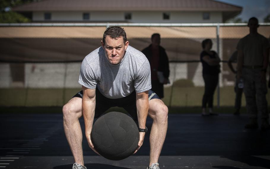 Tech. Sgt. Cole Carroll-Grandegenett, 52nd Civil Engineer Squadron, Spangdahlem Air Base, Germany, performs an over-head medicine ball throw during the beta test of the Explosive Ordnance Disposal Tier 2 fitness test prototype, Sept. 10, 2018, at Eglin Air Force Base, Fla. 
e