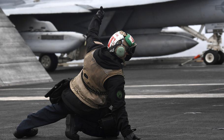 Aviation Electronics Technician 2nd Class Andrew Valera, assigned to the Sunliners of Strike Fighter Squadron 81, signals to launch an F/A-18E Super Hornet from the aircraft carrier USS Harry S. Truman, Sept. 26, 2018.