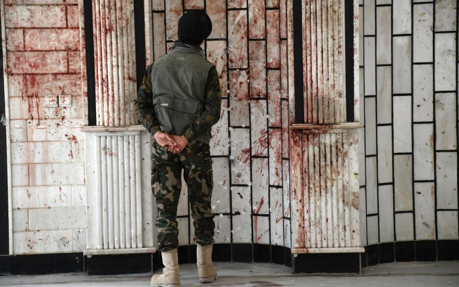 An Afghan security official looks at blood on the walls of the Imam Zaman mosque in Kabul, Afghanistan, on Oct. 21, 2017, a day after an Islamic State suicide bomber launched a deadly attack on the mosque.