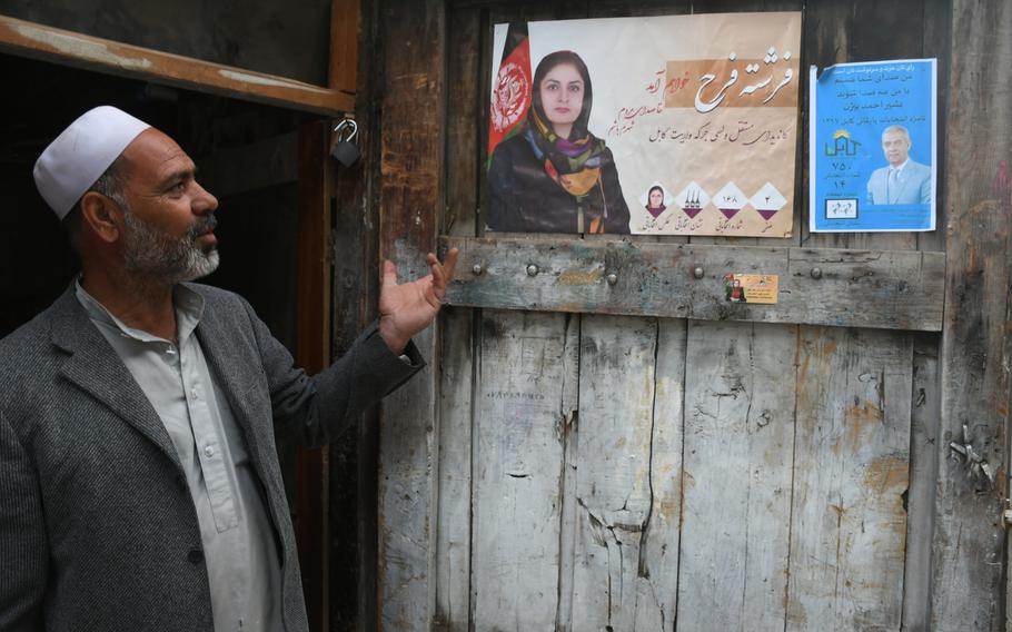 Ghulam Qadir, 60, speaks of the parliamentary candidates he supports, whose election posters adorn his carpentry shop in Kabul, on Wednesday, Oct. 10, 2018. 