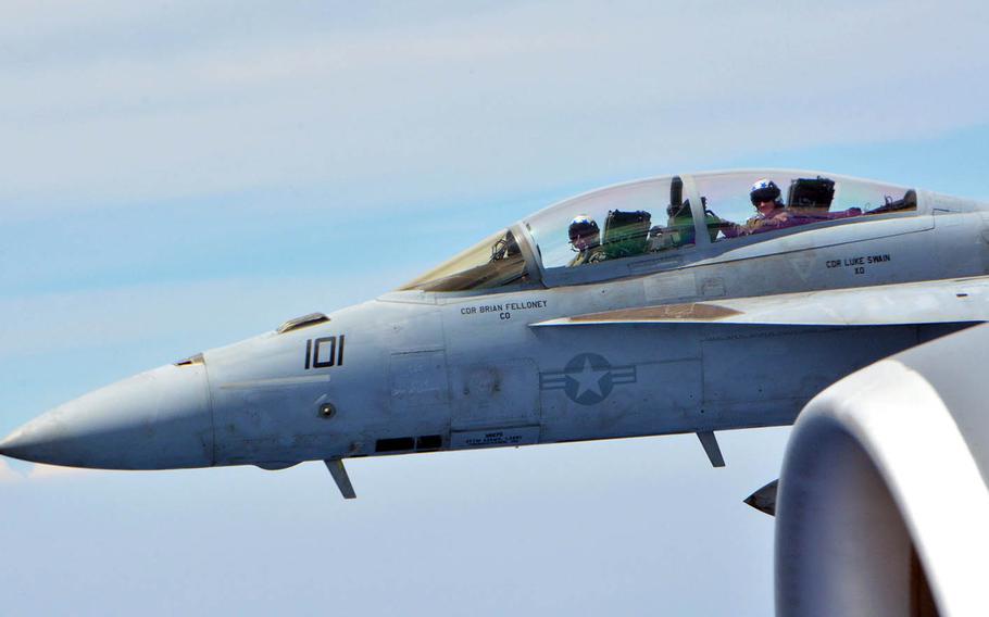 A Navy F/A-18F Super Hornet flies alongside a KC-135R Stratotanker during a Rim of the Pacific drill near Hawaii, July 10, 2018.
