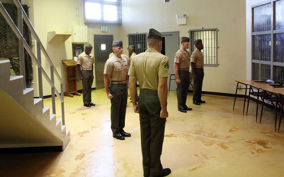 Marines from a Correctional Custody Unit class stand at attention for a uniform inspection at the brig on Camp Hansen, Okinawa, Aug. 31, 2018.