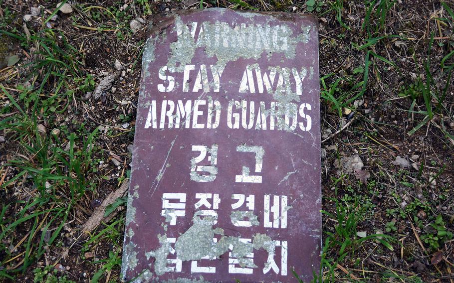 An old sign lays on the grass along the Green Mile, a running trail consisting of steep stairs along the edge of Camp Red Cloud, South Korea, Sunday, Oct. 21, 2018.