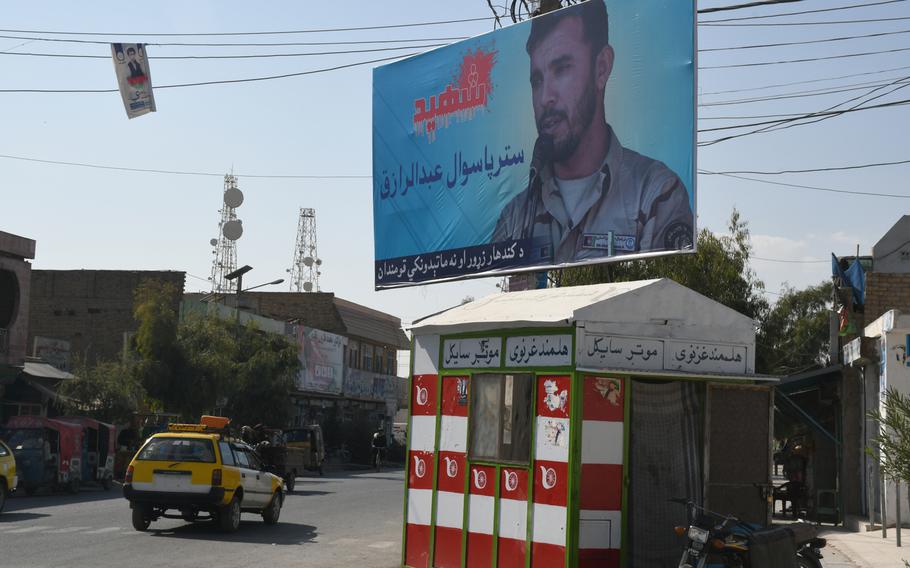 A billboard depicting former Kandahar police chief Gen. Abdul Raziq towers over a busy intersection in Kandahar City on Thursday, Oct. 25, 2018, one week after Raziq was assassinated in an attack that also injured a top U.S. general.